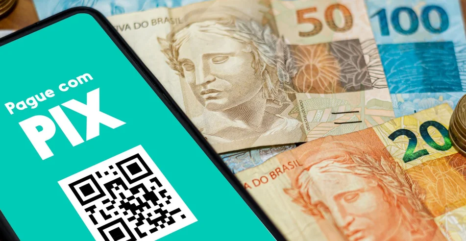 Pix na tela do smartphone com várias moedas ao redor. O Pix é o novo sistema de pagamento e transferência do governo brasileiro e brasileiro.