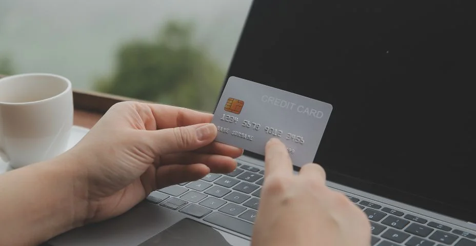 Pagamento on-line, mulher jovem segurando cartão de crédito e tocando na tela do smartphone