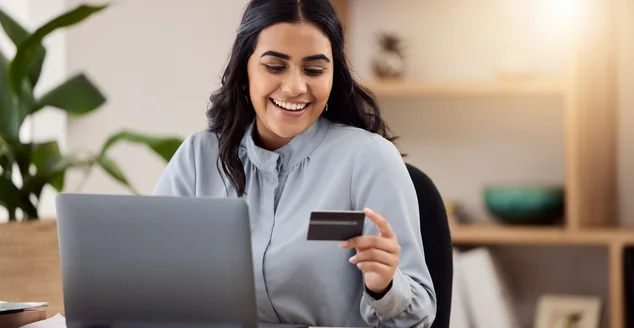 Cartão de crédito, laptop e mulher feliz para compras online, comércio eletrônico e pagamento em fintech em seu escritório. Empregado, indiano ou trabalhador no computador para internet banking, investimento online ou venda