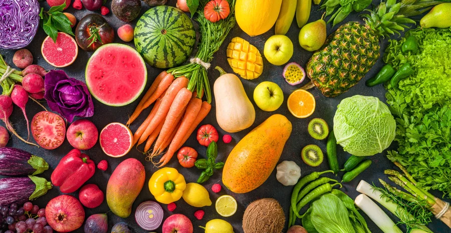 Frutas e vegetais crus coloridos, comida vegana variada, arranjo arco-íris vívido