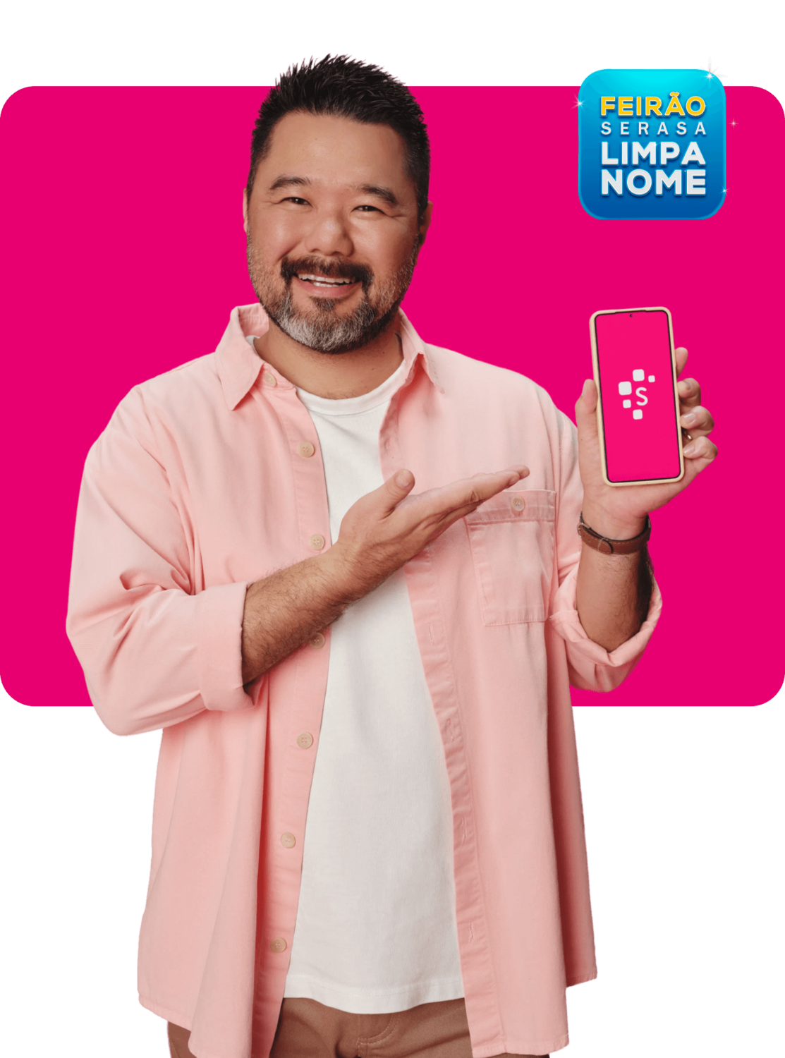 Homem de cabelos curtos e barba grisalha, sorrindo em direção à câmera enquanto segura um smartphone com tela cor-de-rosa com o logotipo da Serasa