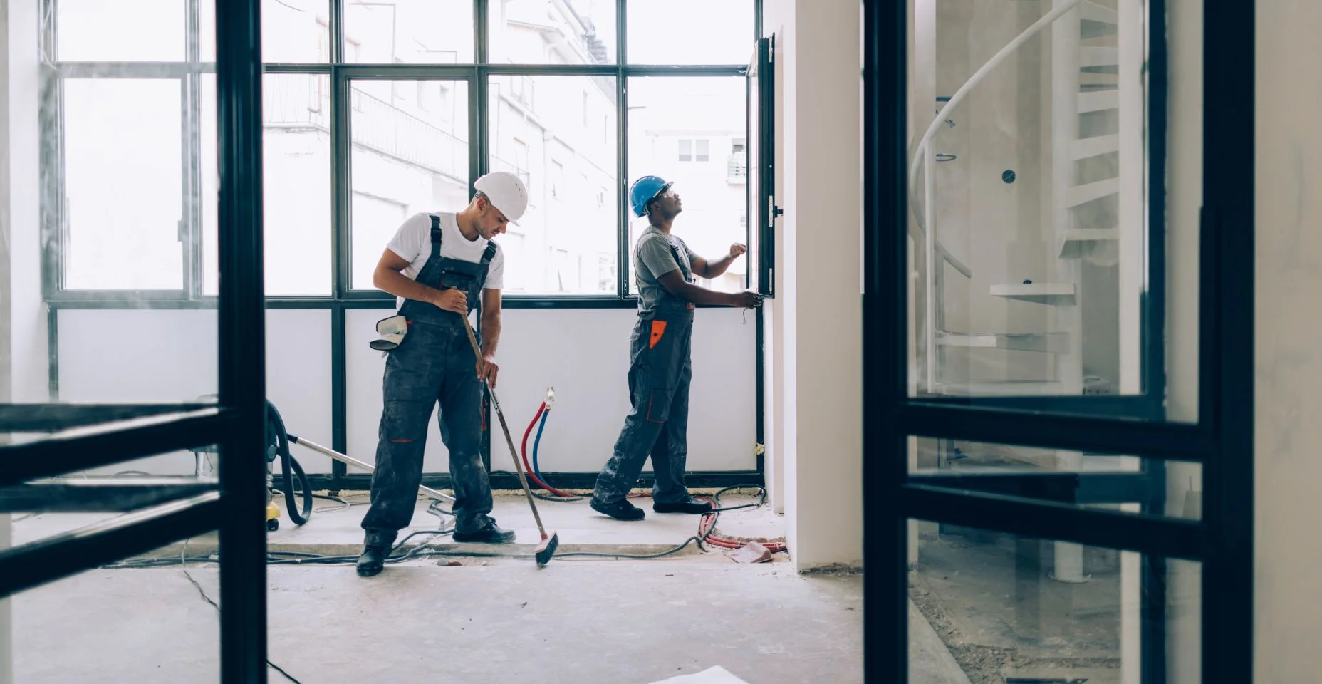 Dois trabalhadores da construção civil trabalhando juntos em uma reforma de apartamento