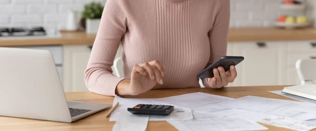 Mulher confiante em óculos contando contas, calculando orçamento em casa