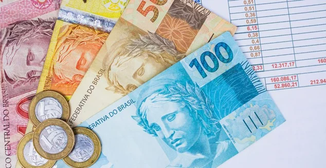 Dinheiro e moedas brasileiros em uma tabela. Imagem do conceito da economia.