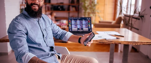 homem mexendo no celular e bolsa de valores