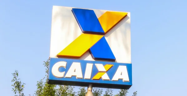 Totem em frente a fachada de uma agência bancária da caixa,