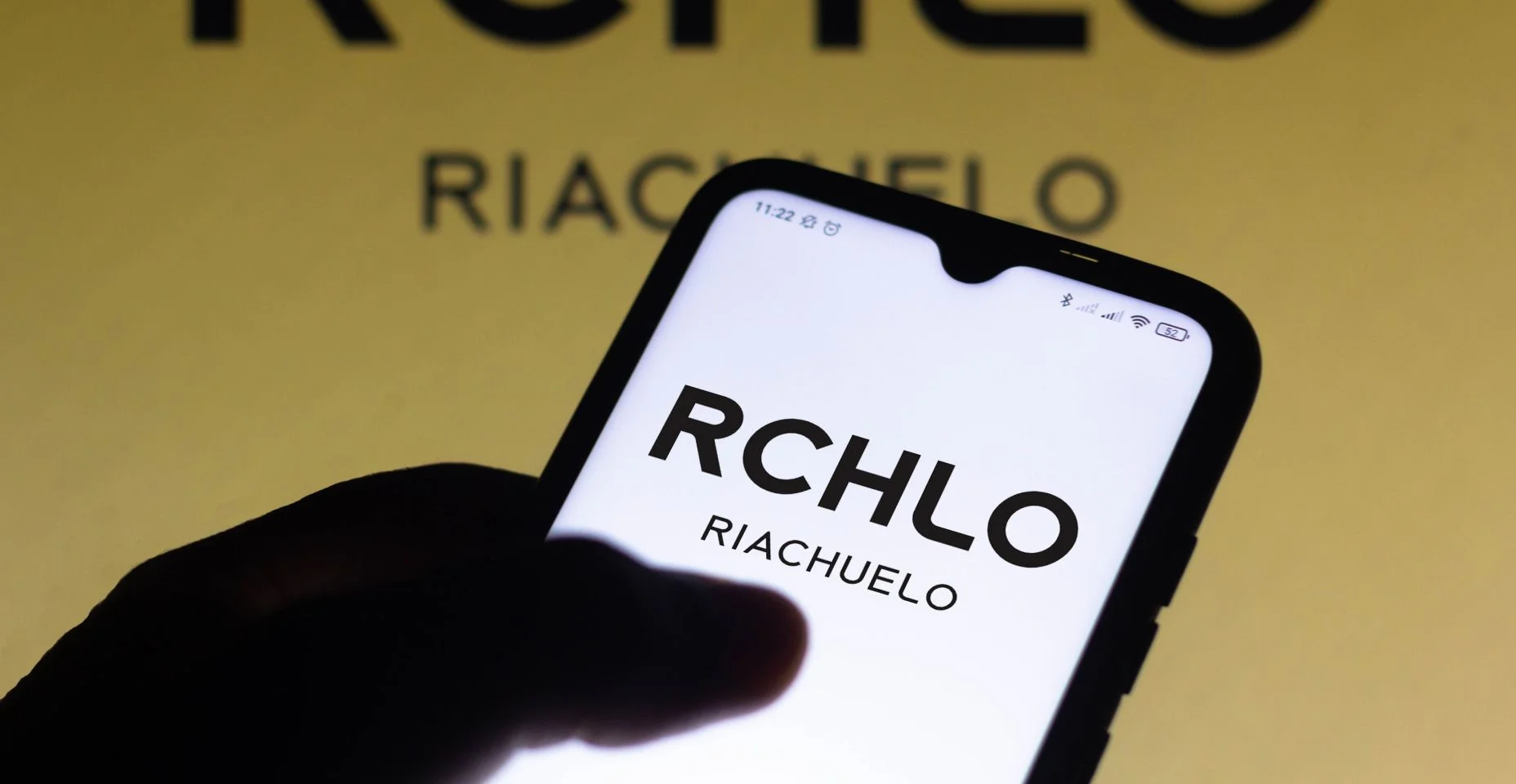 Nesta ilustração fotográfica o logotipo da Riachuelo visto exibido na tela de um smartphone.