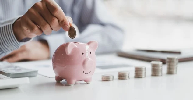 Homem de negócios mão colocando moedas em cofrinho rosa com pilha de dinheiro intensificar crescimento crescente. Planejamento intensifica, economizando dinheiro para plano futuro, fundo de aposentadoria.
