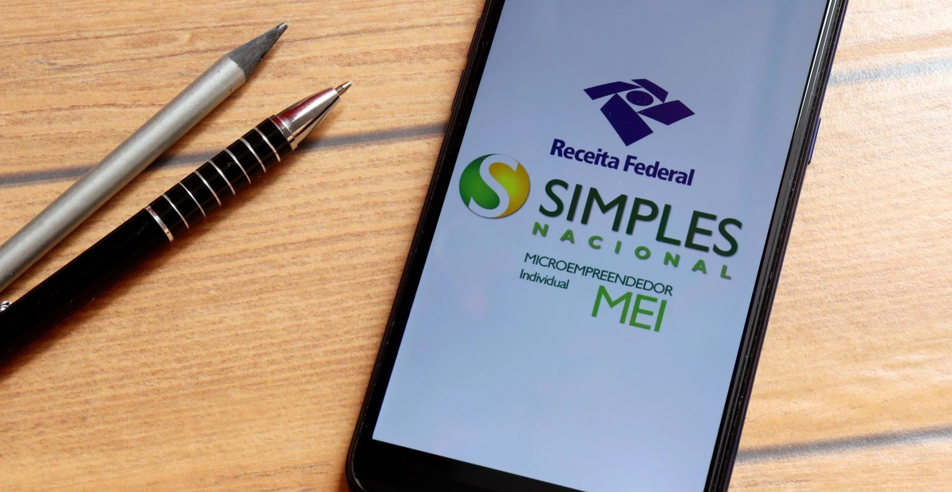 Microempreendedor Individual (MEI – Microempreendedor Individual – Simples Nacional). Aplicativo MEI brasileiro na tela do smartphone na mesa do escritório.