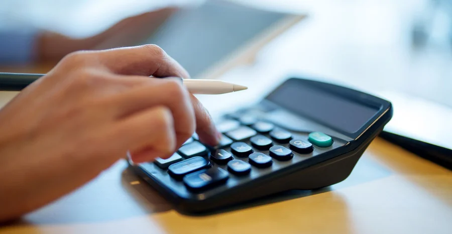 Foto cortada de mulher asiática sentada à mesa fazendo plano financeiro e orçamento com calculadora e tablet