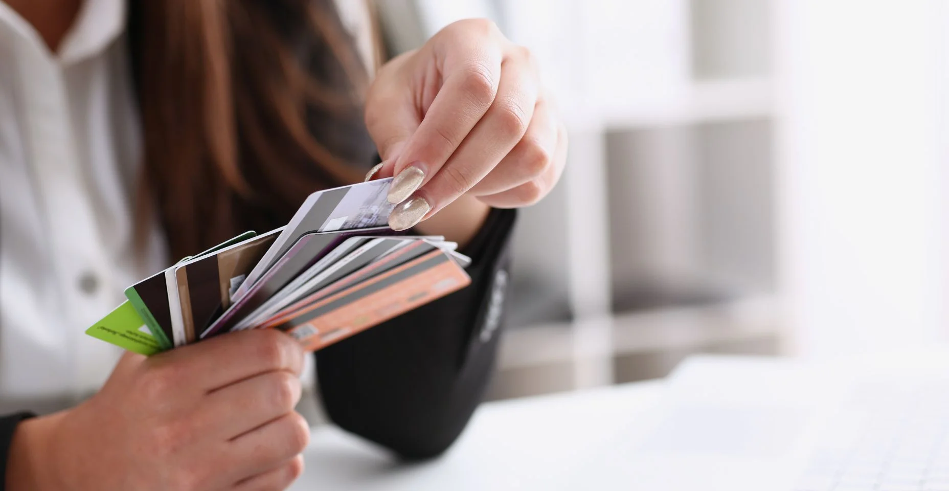 Mulher de negócios no escritório tem um cartão de débito do crédito de plástico nas mãos