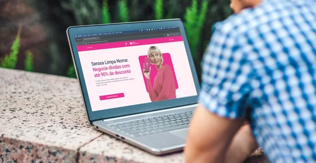 homem no notebook com o site do serasa aberto