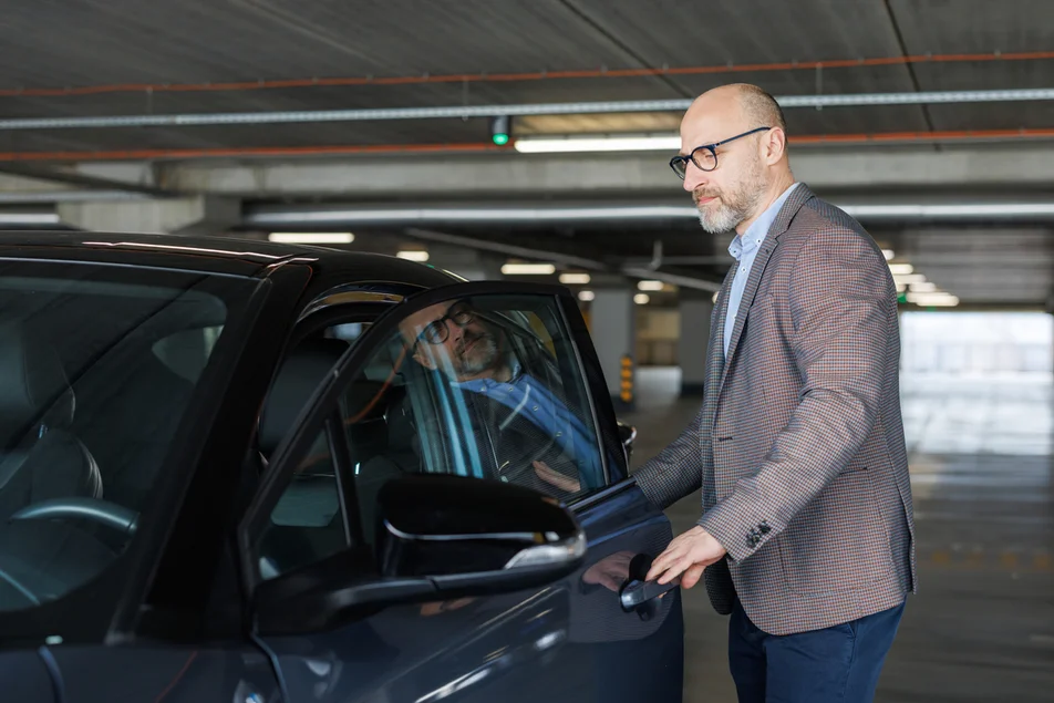 Foto de um empresário confiante entrando em seu carro em uma garagem