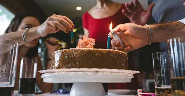 Família que ilumina as velas do bolo de aniversário