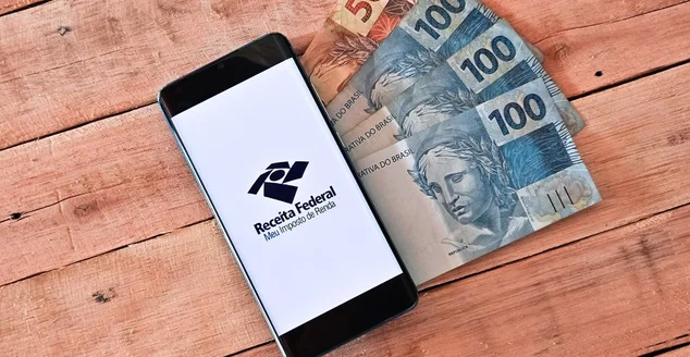 Smartphone com o logotipo da Receita Federal - Meu Imposto de Renda na tela. Declaração de Imposto de Renda no Brasil.