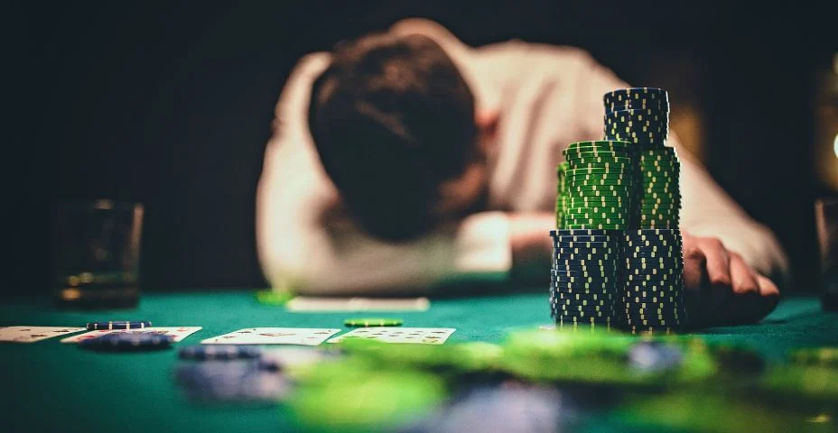 Pessoa cabisbaixa em uma mesa de poker