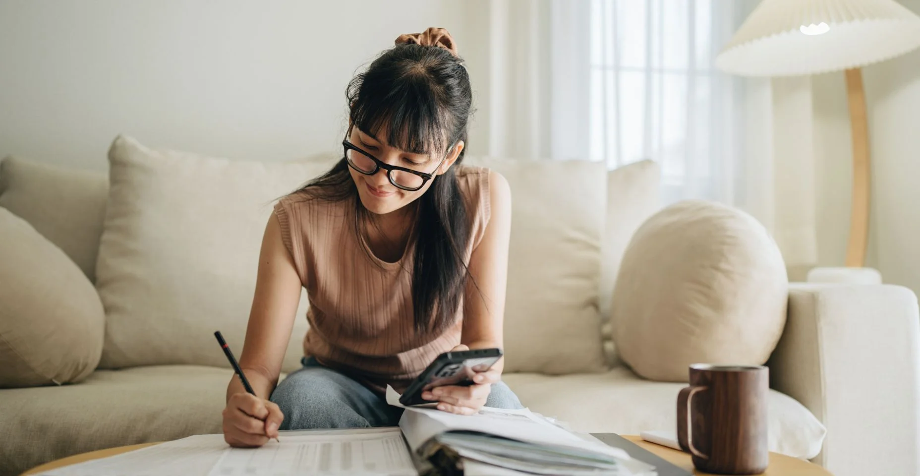 Mulher asiática planejando orçamento e usando calculadora no smartphone.