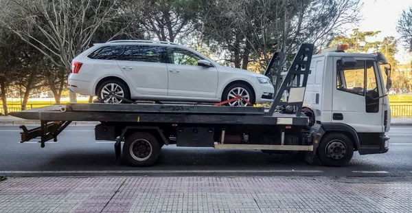 Carro do vagão de estação que está sendo rebocado por um caminhão de reboque