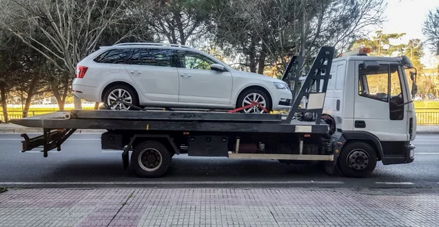 Carro do vagão de estação que está sendo rebocado por um caminhão de reboque