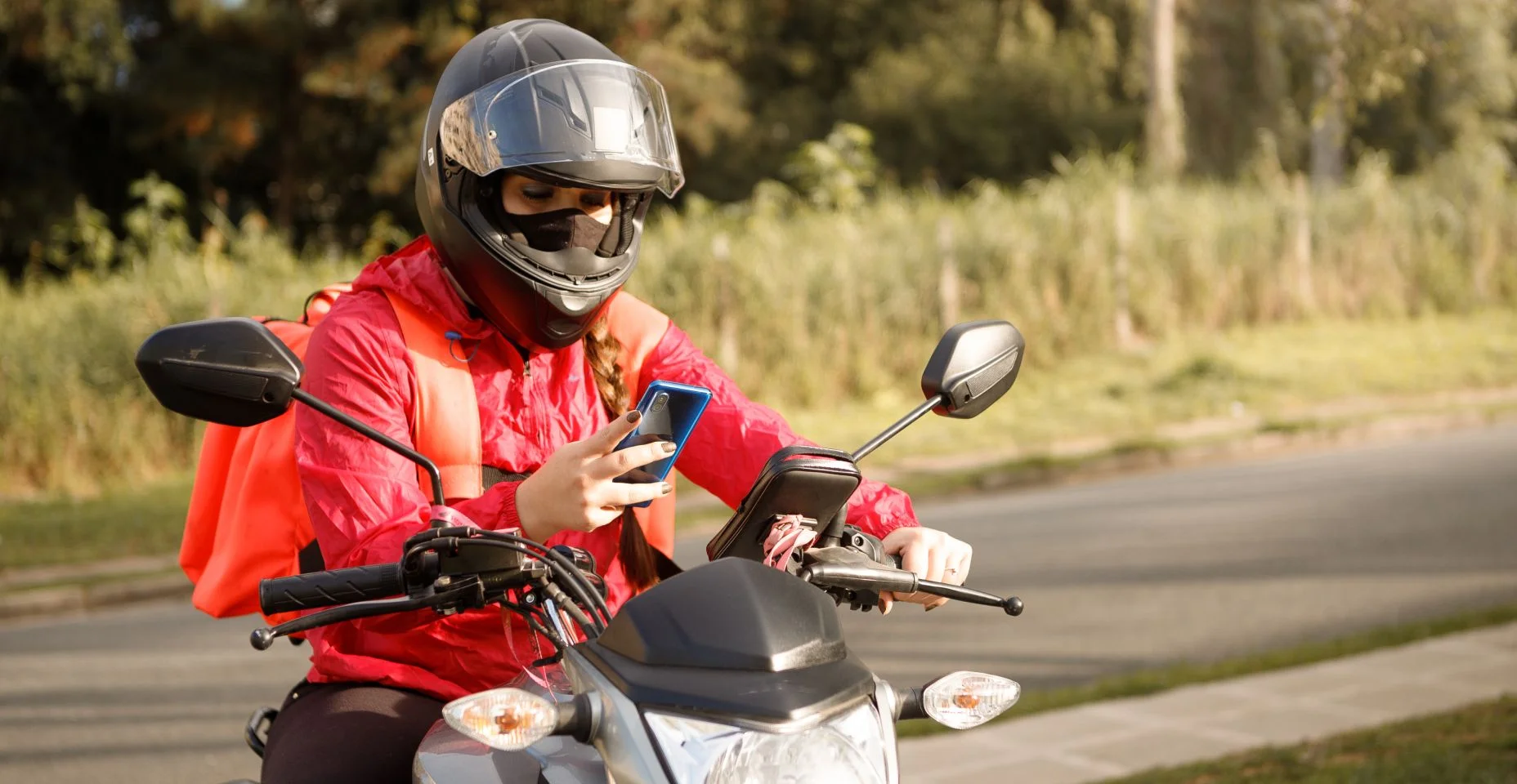 Motociclista entregador chegando ao destino - motogirl