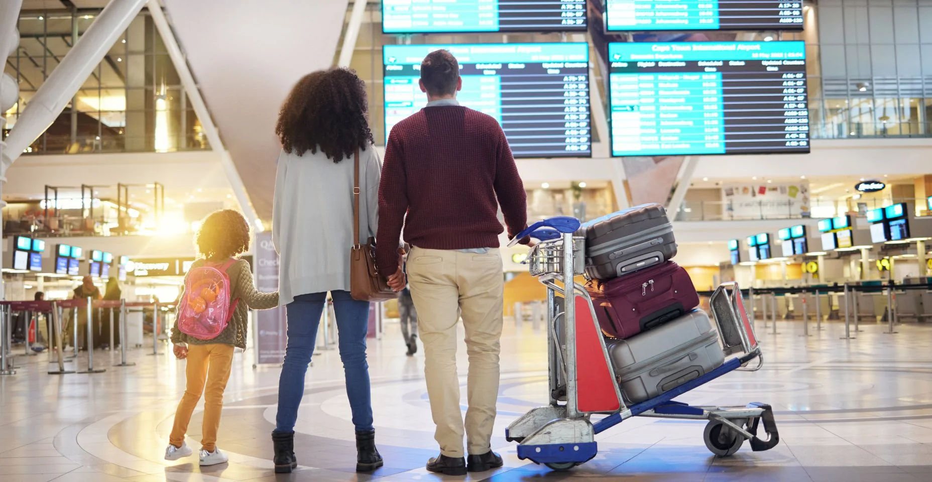 Família, de mãos dadas e viagem esperando no aeroporto verificando horários de voo para partida