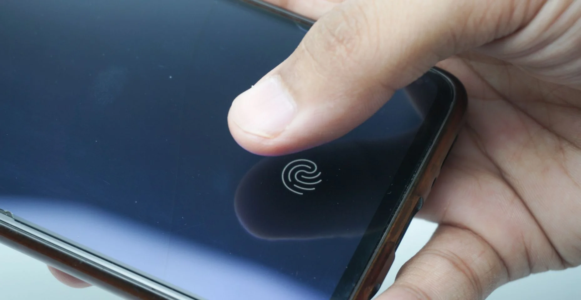 Scanner de impressão digital na tela do telefone. Smartphone com tela sensível ao toque com zona para tocar o dedo humano, para desbloquear o dispositivo.