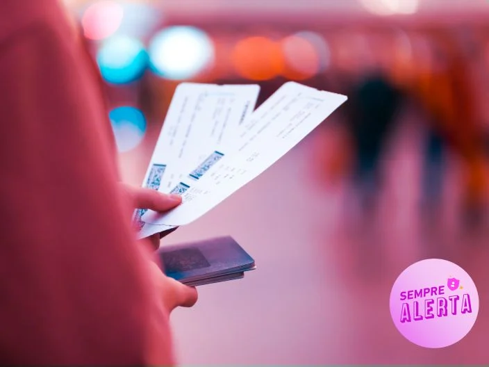 Mulher segurando ingressos e um celular para ilustrar o artigo sobre o golpe do ingresso falso