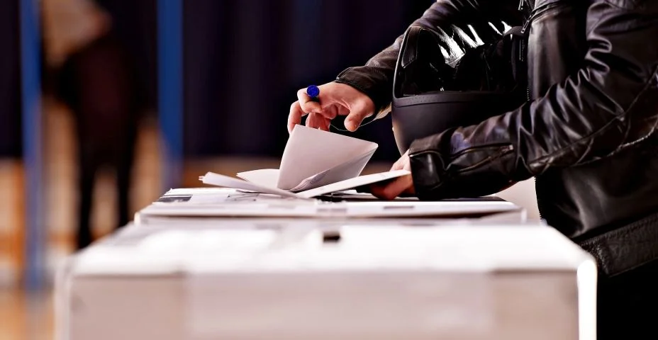 Mãos com um carimbo lançando um voto