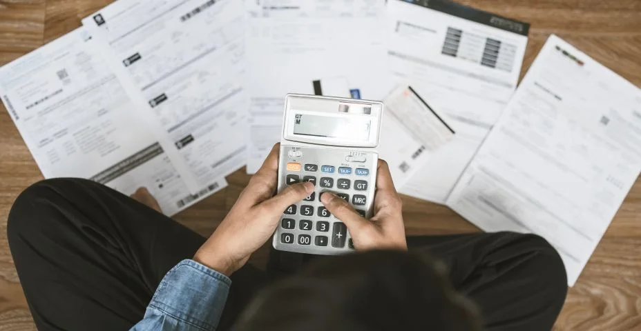 Vista superior homem sentado no chão estressado e confuso calculando despesas de fatura ou conta, não tendo dinheiro para pagar pensando em levar a casa para hipoteca causando dívidas, conceito de falência.