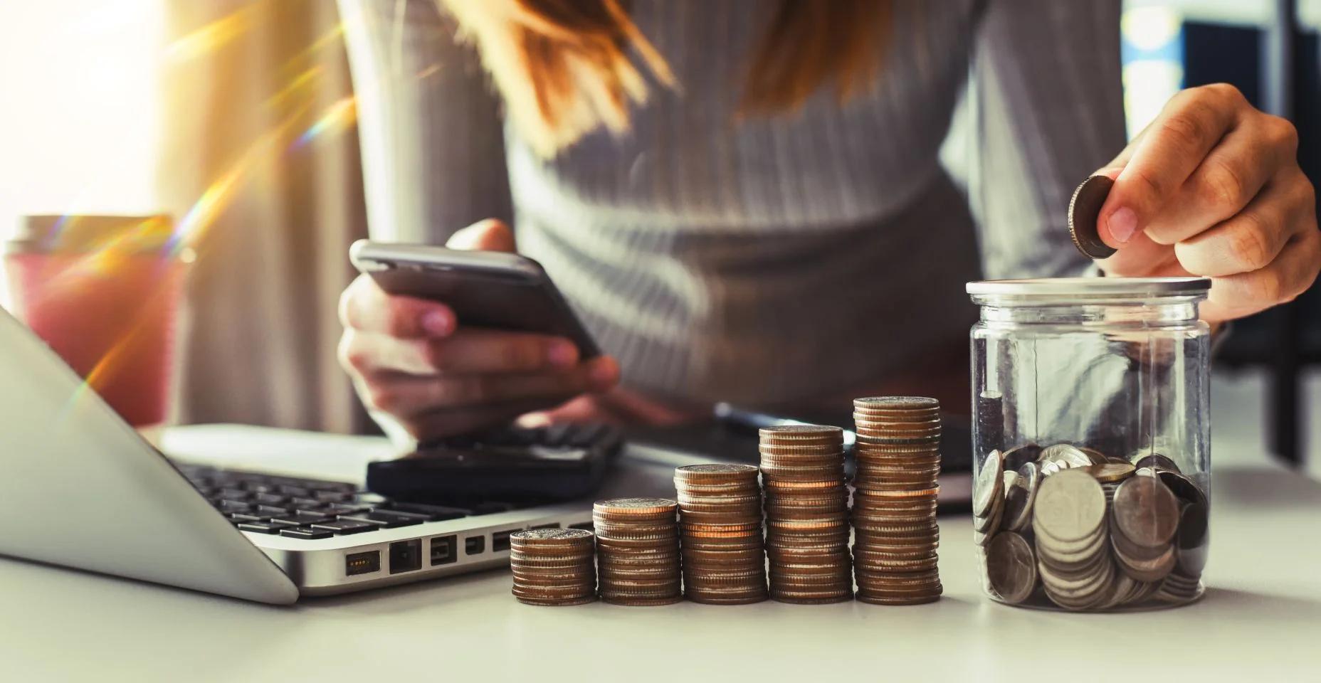 empresária segurando moedas colocando em vidro usando smartphone e calculadora para calcular o conceito de economia de dinheiro para contabilidade financeira