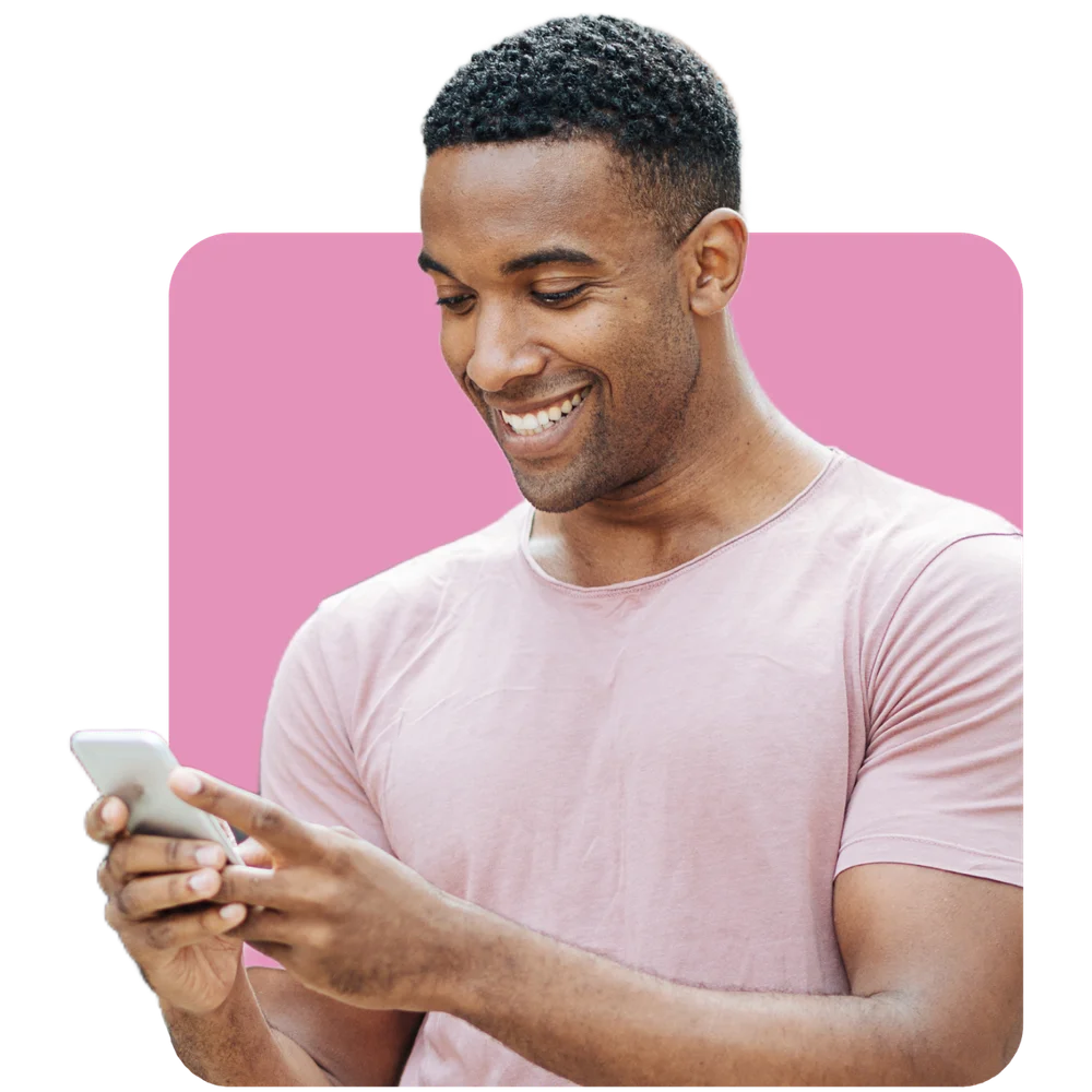 Homem preto sorrindo olhando para tela de celular