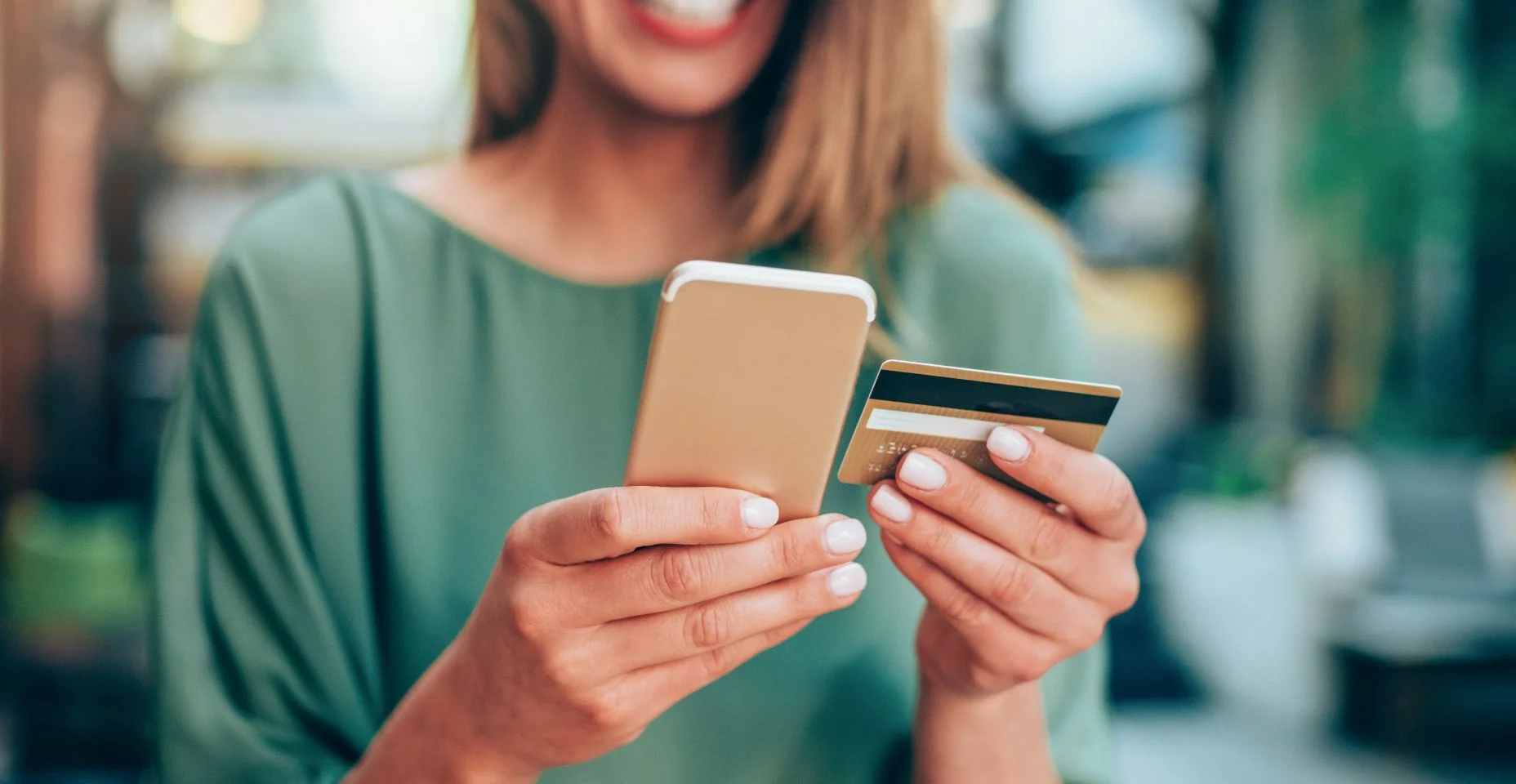 Cartão de crédito e texting felizes da terra arrendada da mulher