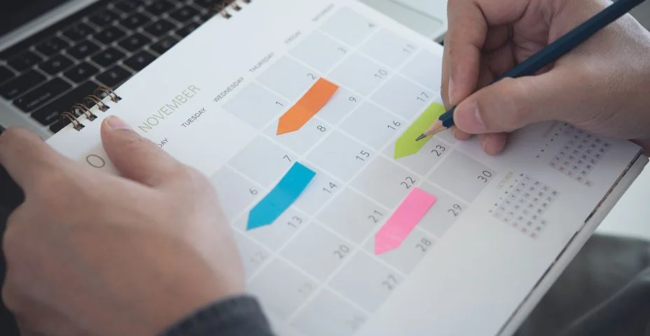 Calendário 2023 Calendário de planejamento de eventos cronograma cronograma plano em organizar cronograma. Organizador da agenda do organizador por organizador agenda. Nota da mão do homem de negócios no caderno com o planejador do calendário na mesa