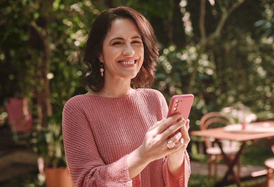 Mulher segurando celular com a tela de minhas contas