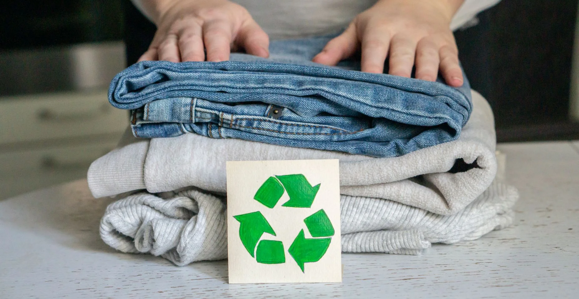 Conceito de reciclagem de roupas. Uma pilha de roupas está na mesa de reciclagem. Coleção de roupas para reciclagem