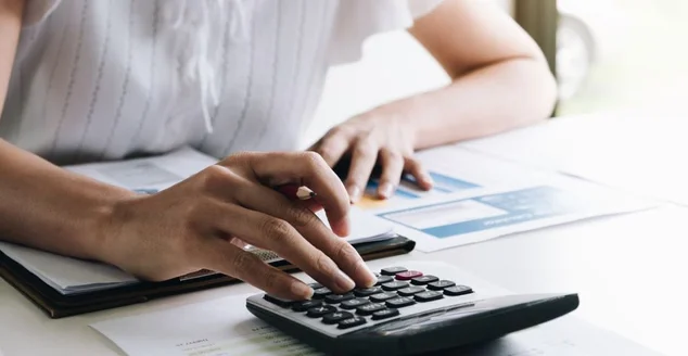 Mulher mexendo na calculadora