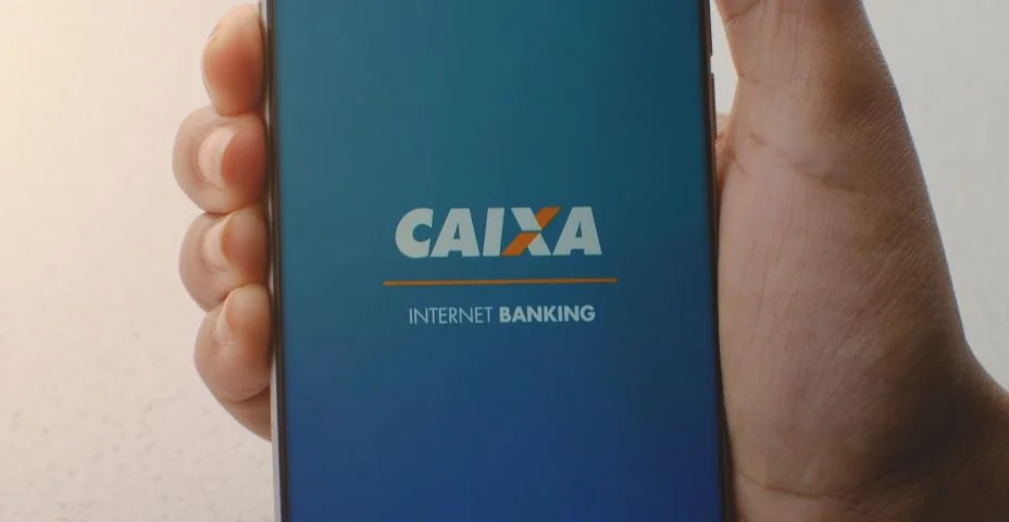 Smartphone em close mostrando o aplicativo da Caixa Econômica Federal para internet banking, solução financeira na tela.