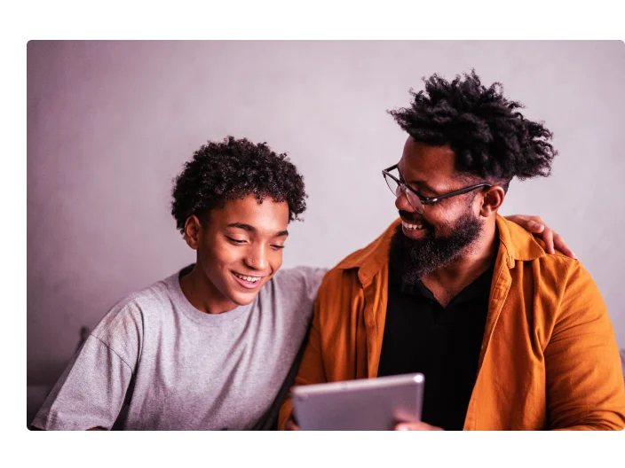 Pai e filho felizes usando tablet digital em casa