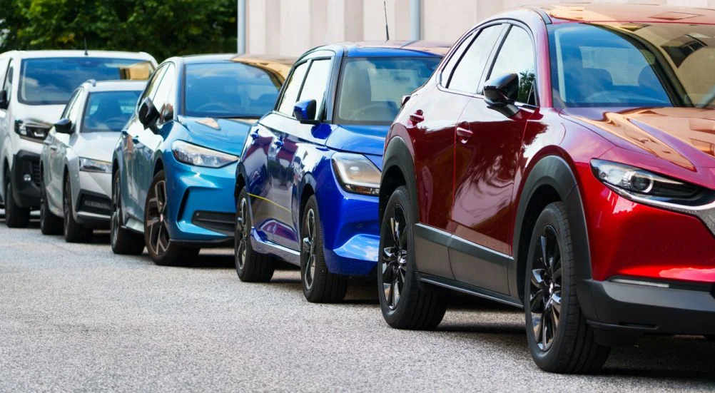 Carros coloridos estacionados na rua estreita