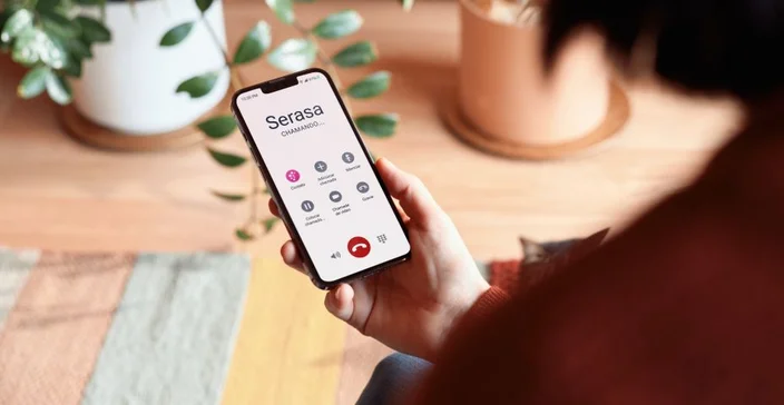 mulher segurando smartphone com tela personalizável em casa