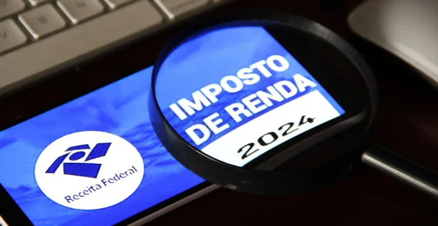 Imposto de renda 2024 da receita federal segurando celular com aplicativo e dinheiro.