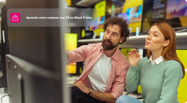 Um casal feliz está na seção de eletrônicos de uma loja de varejo, olhando para uma tela moderna de tela plana