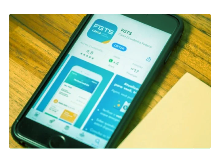 celular encima de uma mesa aberto na loja de aplicativos e fazendo o donwload do app fgts