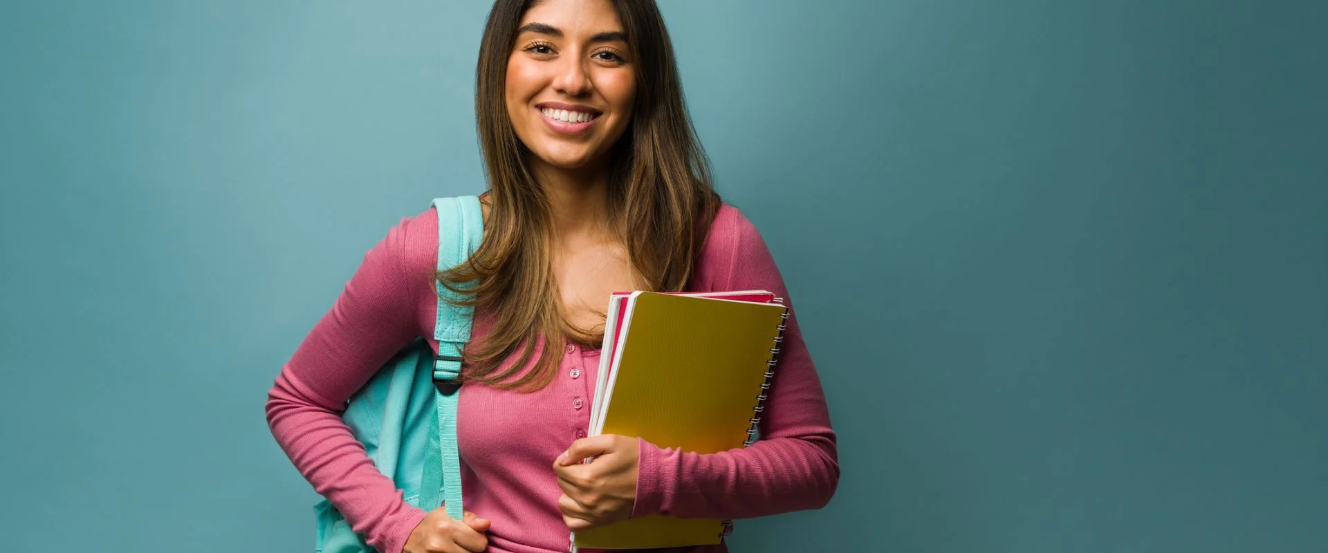 garota segurando livros representando uma estudante