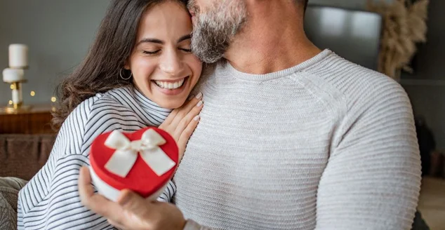 Casal romântico em casa. Homens dando um presente para sua namorada