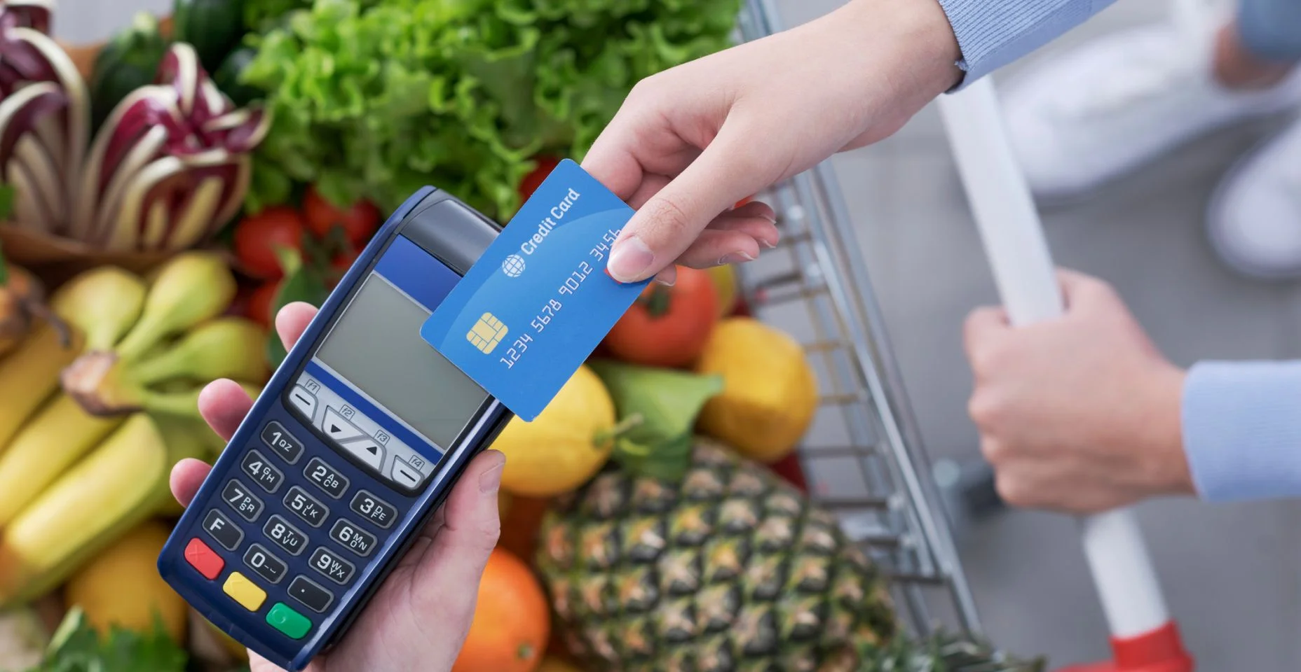 Mulher pagando por mantimentos usando um cartão de crédito