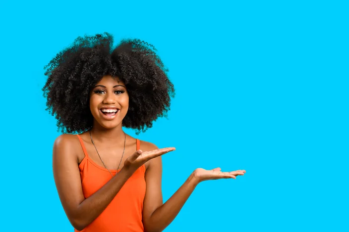 mulher negra sorrindo com as mãos estendidas.