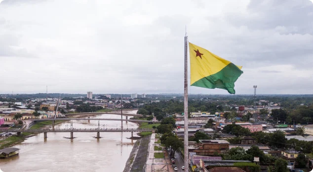 Vista aérea do zangão do rio e da bandeira de Acre no amazon. Edifícios do centro da cidade de Rio Branco, casas, ruas, pontes no dia nebuloso. Brasil