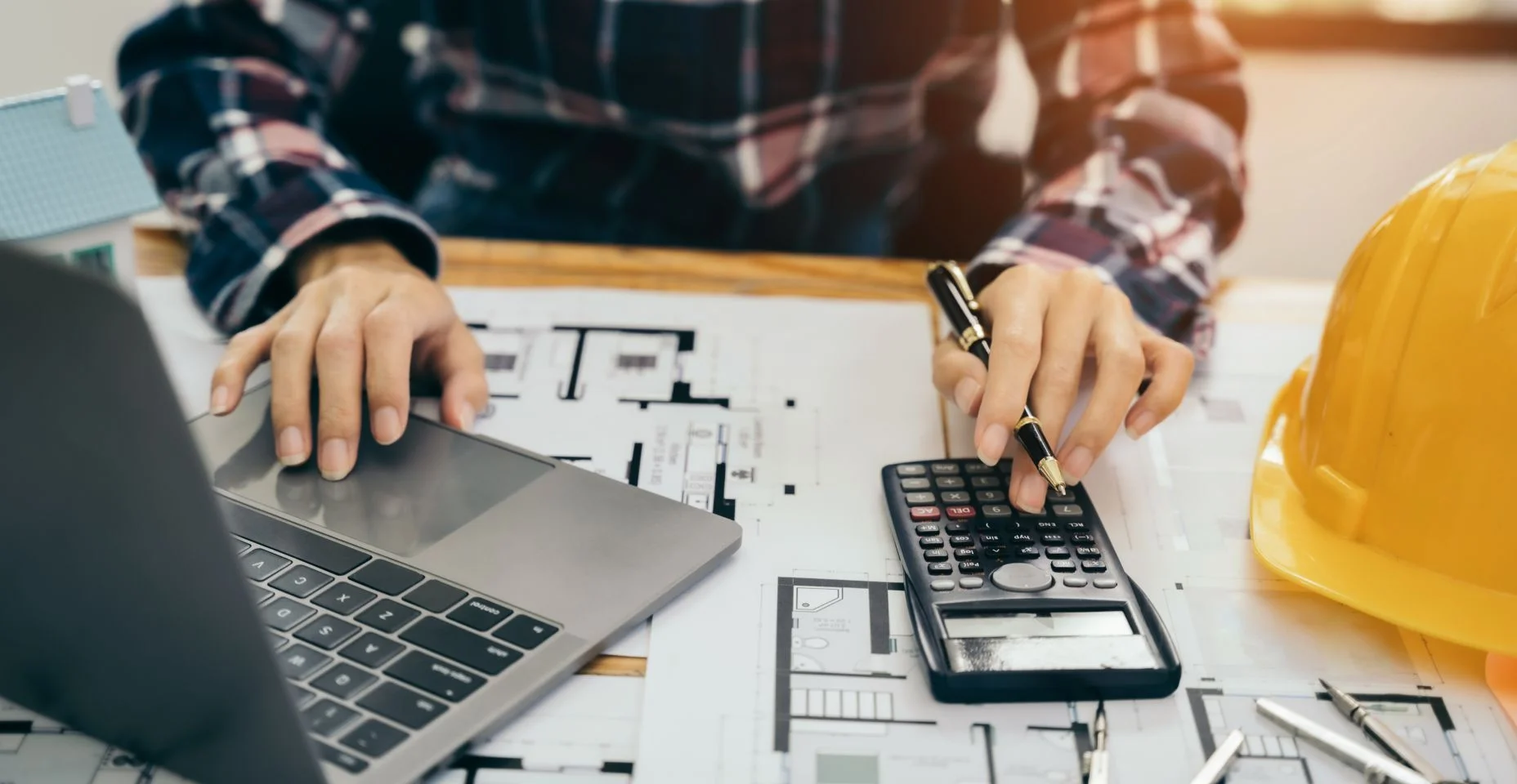 engenheiro civil ou arquiteto usando calculadora para calcular o custo para trabalhar no projeto de design do plano de construção no escritório.