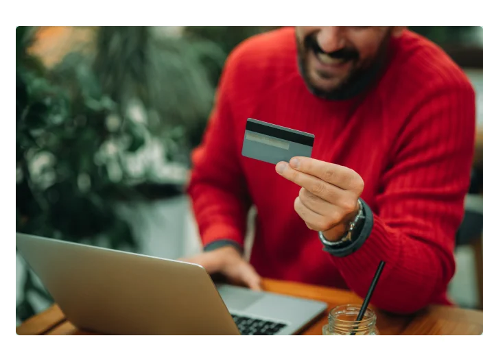 homem com cartão na mão entendendo os ricos do credito rotativo